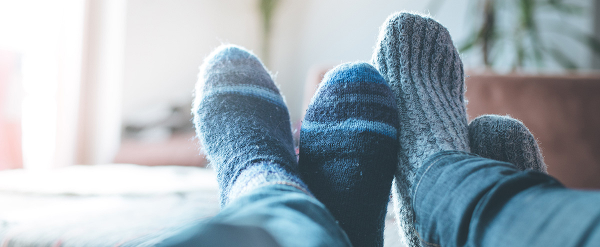 Feet in socks, a couple relaxing. DiSC can help couples meet challenges and grow closer.