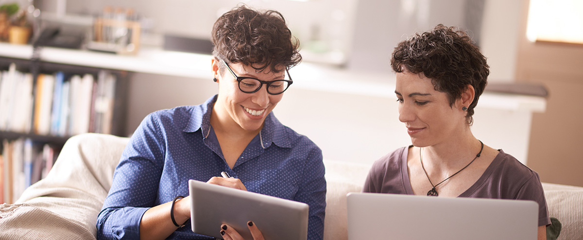 Couple looking at tablet together, tools like DiSC comparison reports help couples communicate