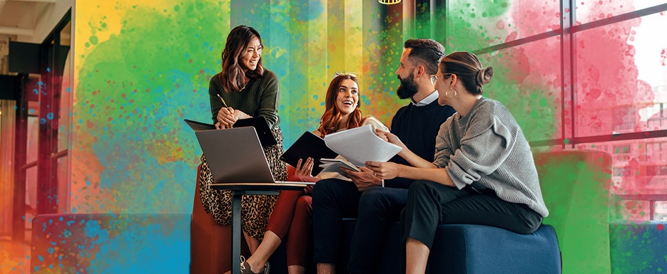 Team of four collaborating in lobby, example of cohesive team communication