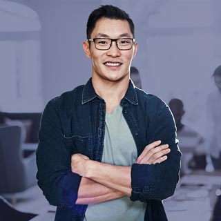 Man in an office, smiling with crossed arms